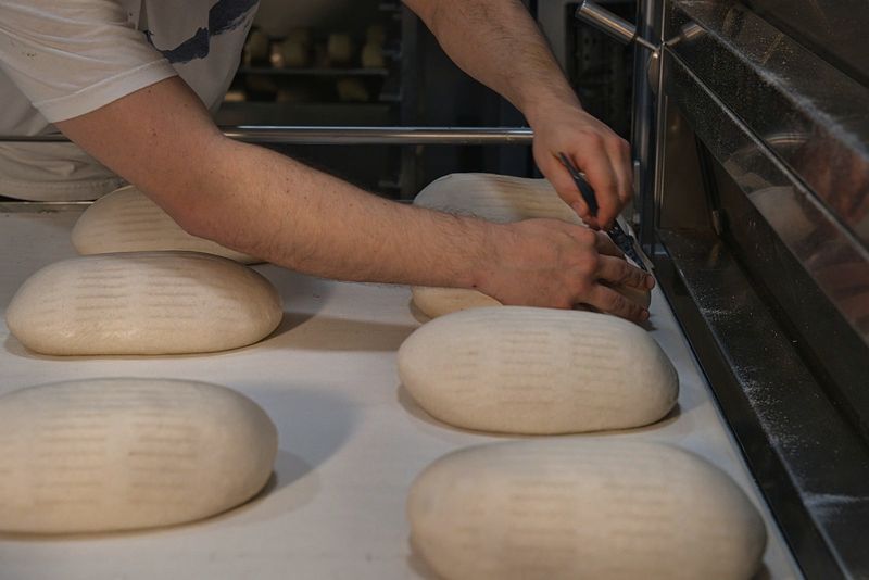 Mains d’un boulanger façonnant des pâtons