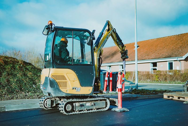 Opérateur aux commandes d’une mini-pelle sur un chantier